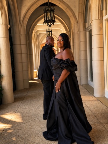 Wilda and Sean posing in an elegant corridor